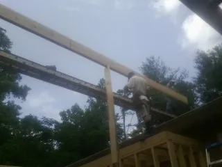 Carpenter setting a ridge beam over a new addition frame — Ice Dam Removal by Roofing Brothers in Mendham