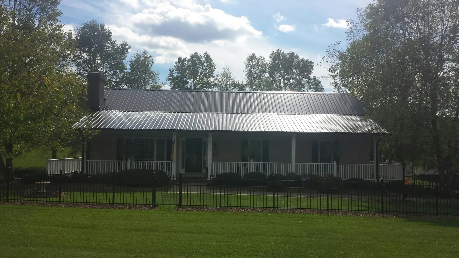 Gray metal roof on a brick ranch with a full width front porch — Gutter Guard Installation work by our crew in Mendham