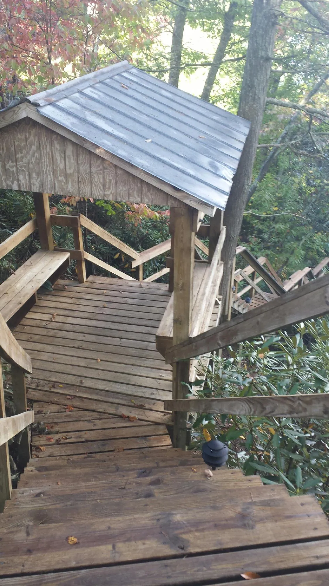 Metal roofed shelter over wooden steps on a wooded walkway — Skylight Repair & Installation work by our crew in Mendham