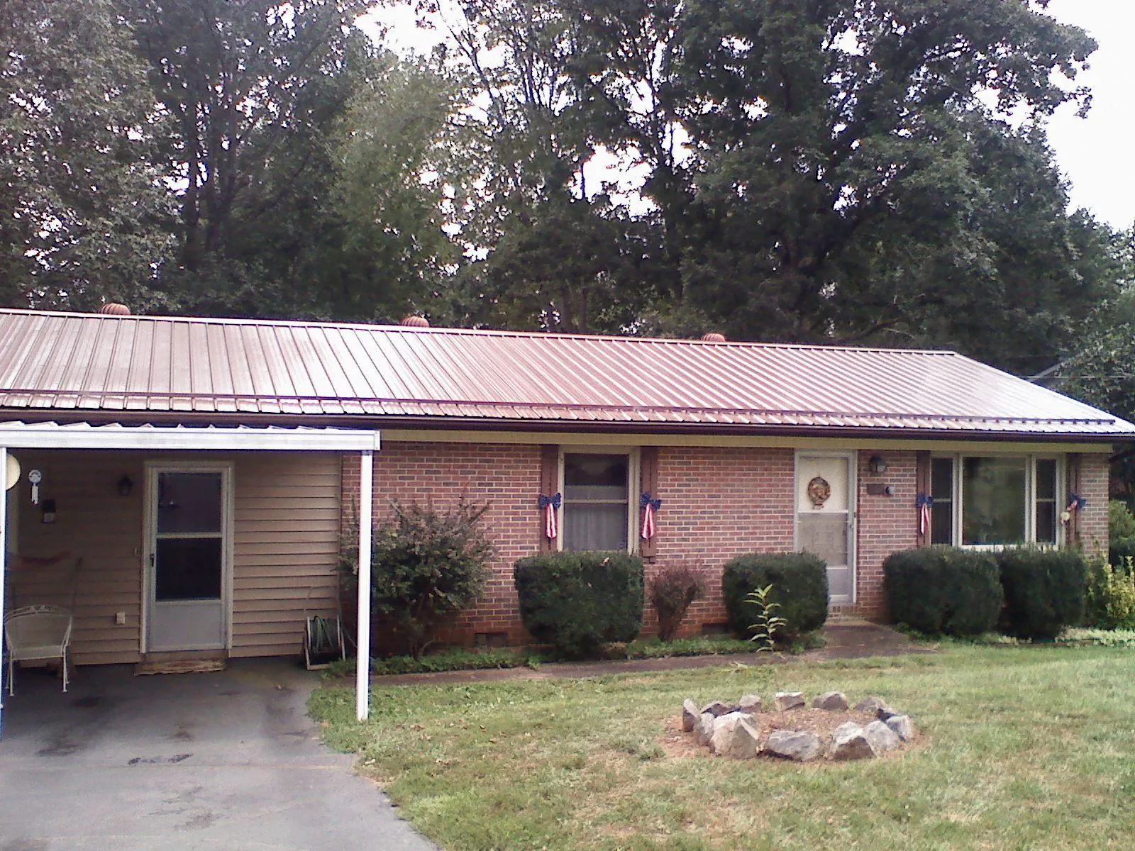 Bronze metal roof and carport on a brick ranch home — Roof Repair work by our crew in Mendham